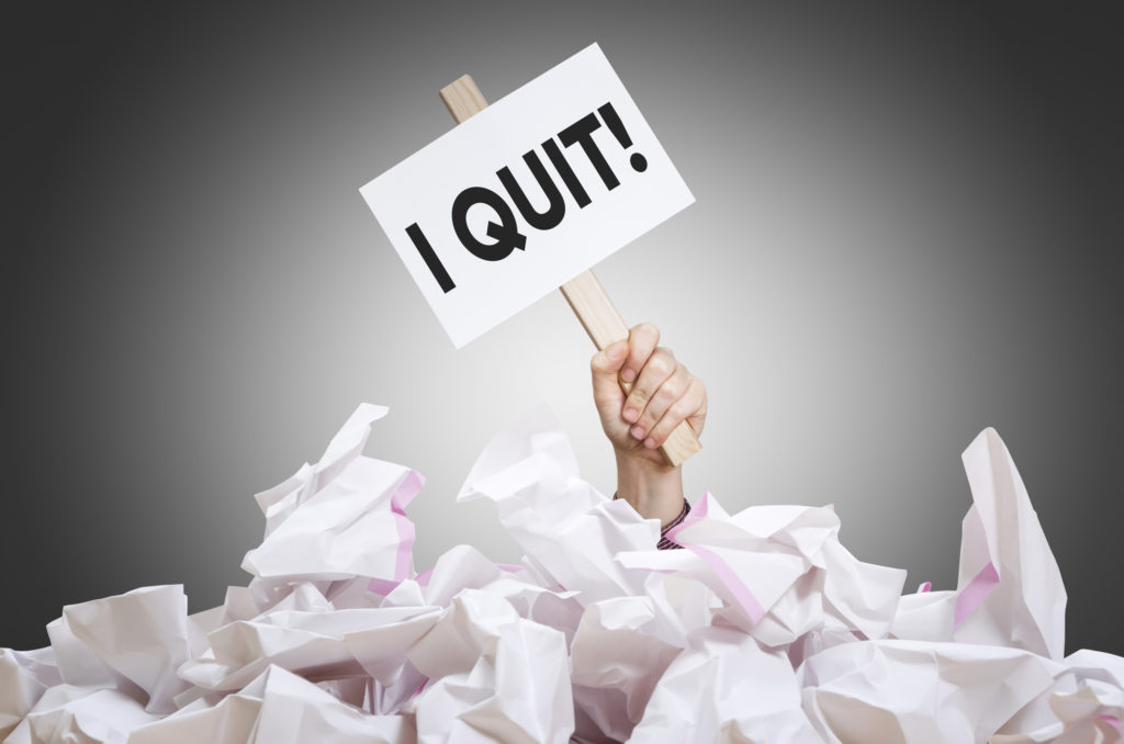 how to quit job image I quit placard in hand with crumpled paper pile